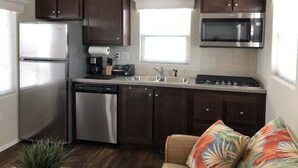 A kitchen with dark wooden cabinets, stainless steel appliances, a toaster, and a microwave.