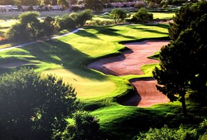 Ein Golfplatz mit gepflegten Grüns, Sandbunkern und einer klaren Spielbahn.