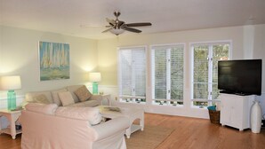 A living room with a sofa, a television, a ceiling fan, and large windows with blinds. - SOUND FRONT!, Kite-In/Out! Sunsets! Dock!  (Salvo)