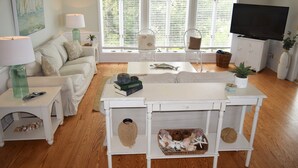 A living room with a white sofa, a coffee table, a TV, and a large window with blinds. - SOUND FRONT!, Kite-In/Out! Sunsets! Dock!  (Salvo)