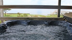 A hot tub with a view of a grassy area and a bridge in the background. - SOUND FRONT!, Kite-In/Out! Sunsets! Dock!  (Salvo)