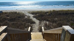 A wooden boardwalk leading to a beach with a clear view of the ocean. - "Oceans Edge" - Luxury Oceanfront home, 4 Bedrooms / 2.5 Bathrooms (Holden Beach)