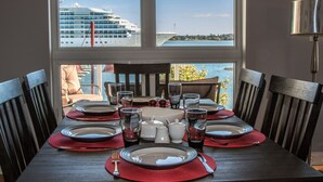 A dining table set for eight with a view of a cruise ship and water. -  Walk to Fine Restaurants & Confederation Centre of The Arts. (Charlottetown)