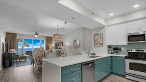 A modern kitchen with teal cabinets, a dishwasher, and a large island. - Sumer dates are open! OCEAN FRONT & beautiful ocean view! Reduced rates! (Miramar Beach)