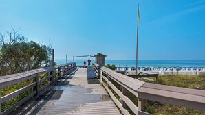 A wooden boardwalk leading to a beach with a lifeguard station and beach umbrellas. - Sumer dates are open! OCEAN FRONT & beautiful ocean view! Reduced rates! (Miramar Beach)