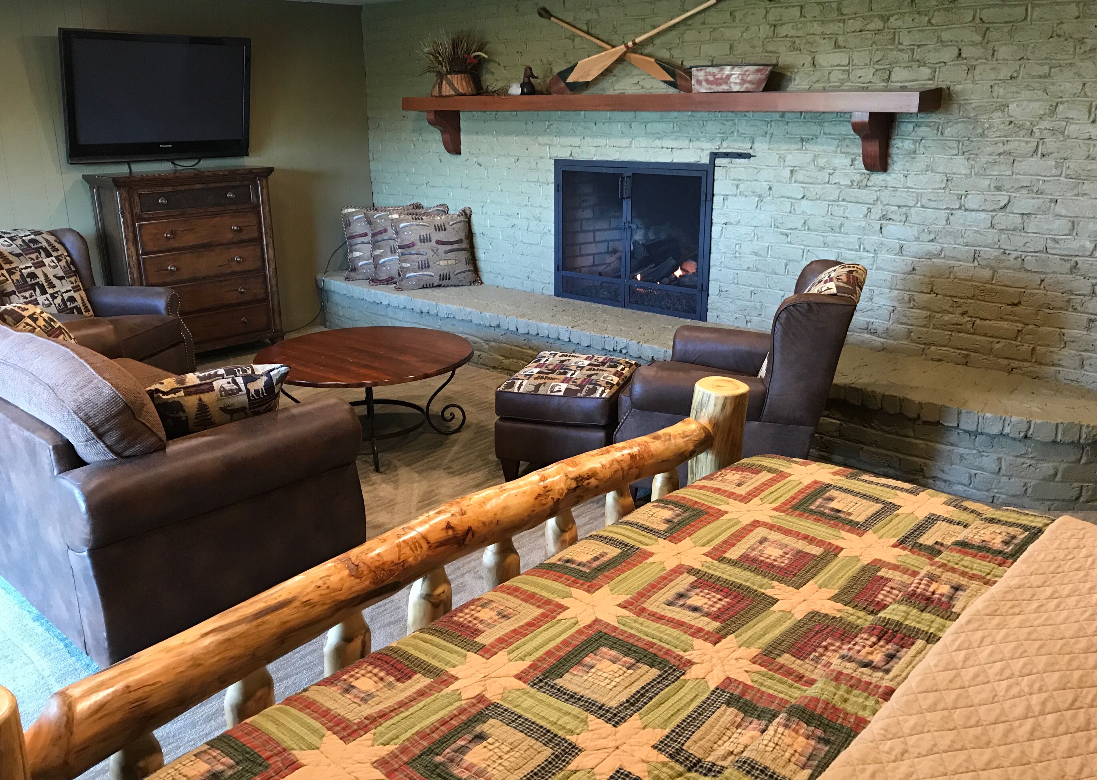 Una sala acogedora con chimenea, muebles de cuero y televisor.