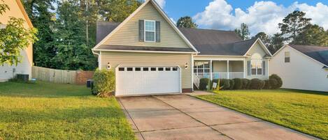 A single-story house with a garage, a front porch, and a well-maintained lawn.