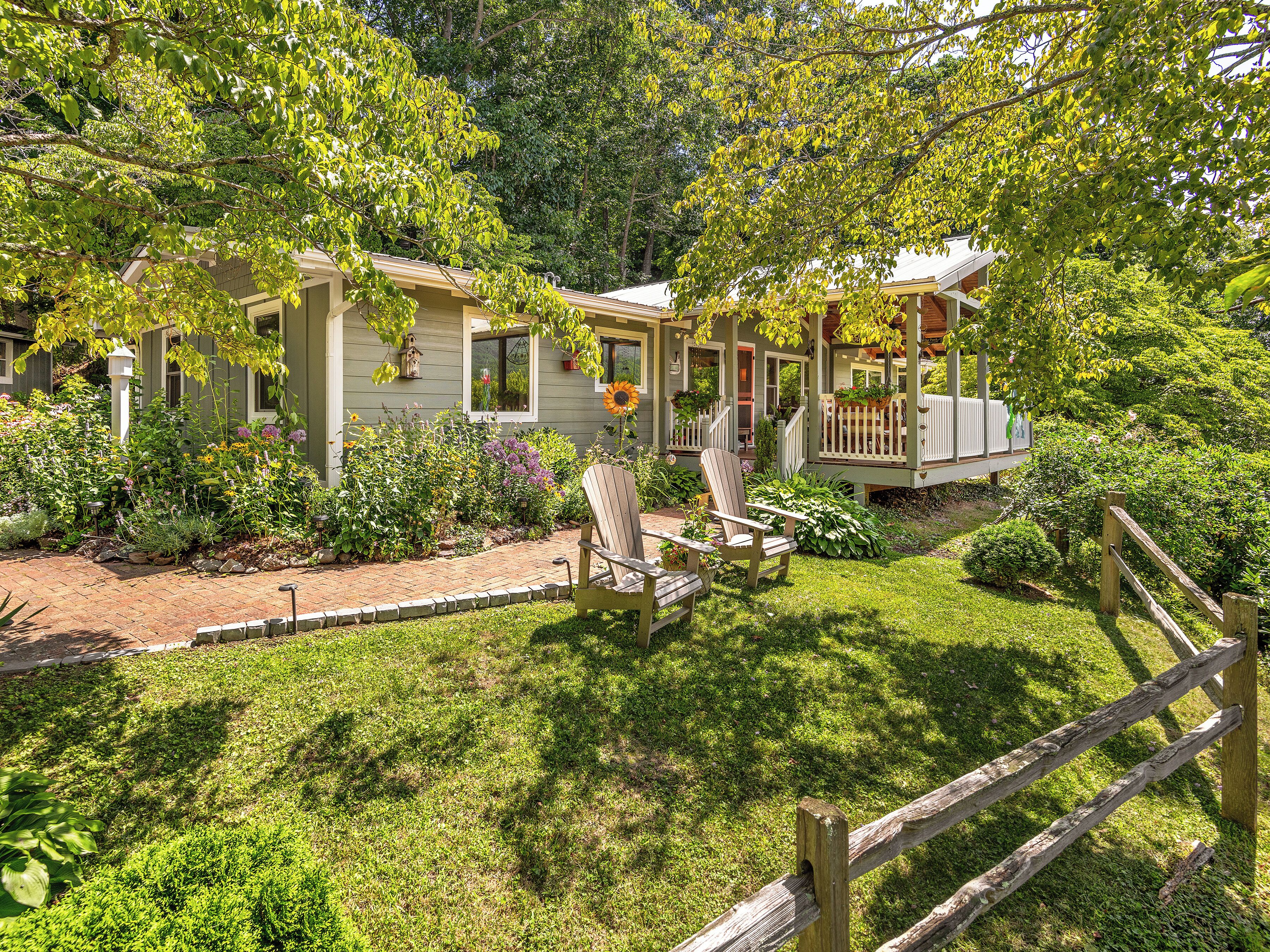 A house with a porch, a garden, and a wooden fence.