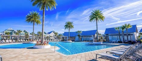A resort pool area with multiple pools, palm trees, and lounge chairs.