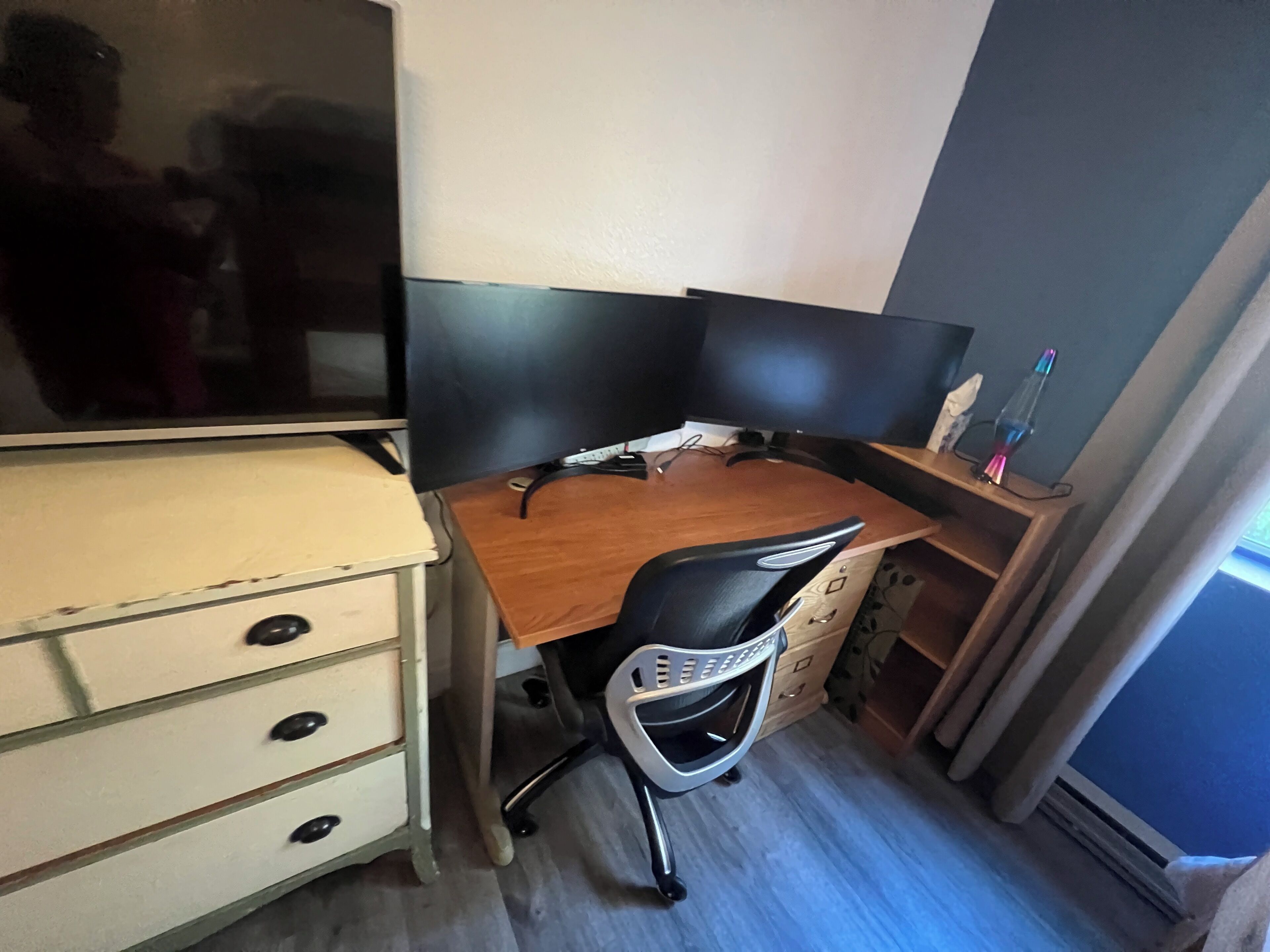 A small office space with a desk, chair, and a television.