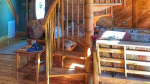 A wooden spiral staircase with a view of the living room below. - Secluded LAKEFRONT Chalet: 2.8acres, Dock, Kayaks and Canoe, Pet Friendly, Wifi (Butler)