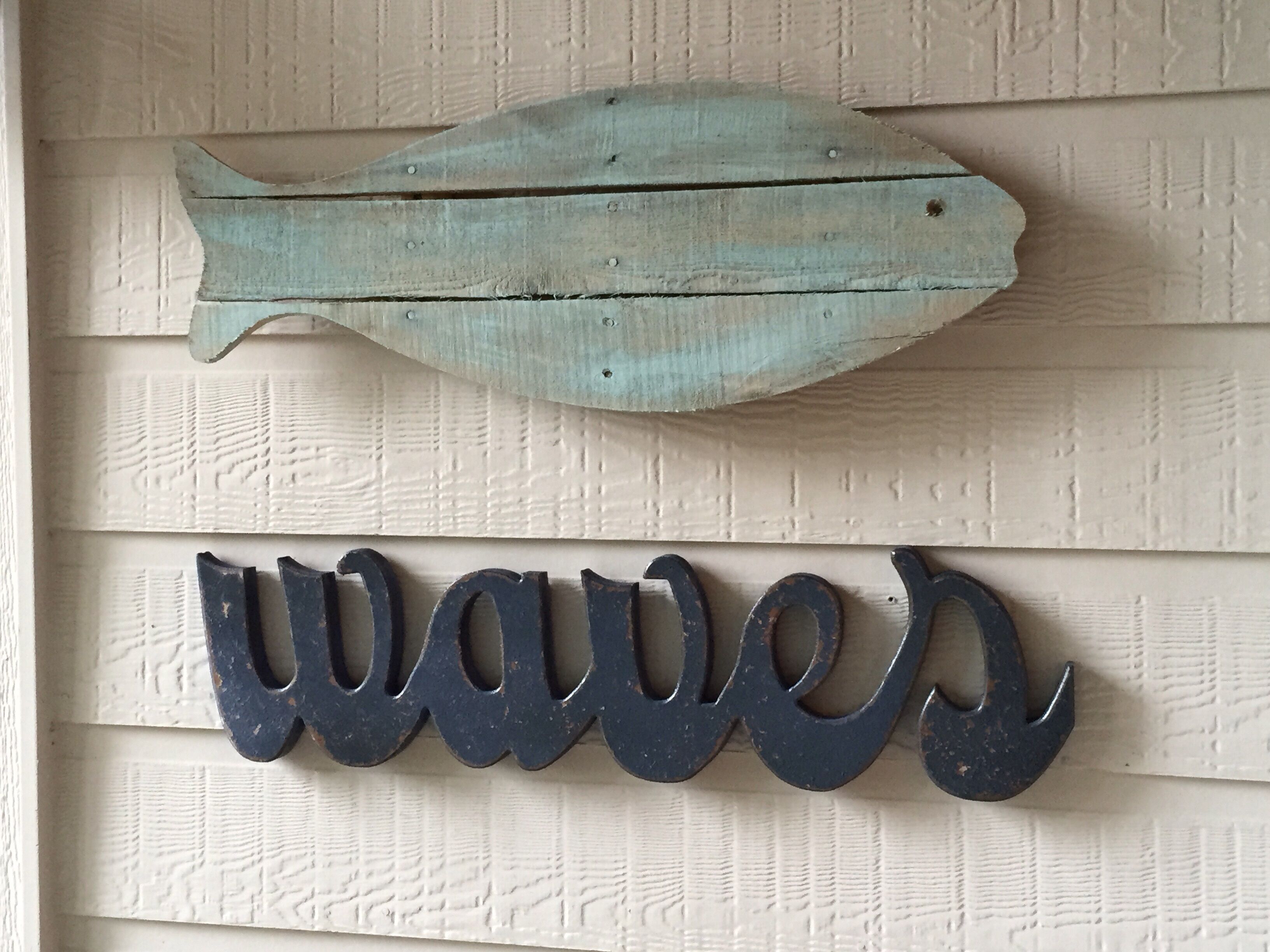 A decorative fish and the word "waves" on a wall.