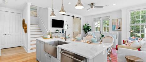 A modern kitchen with a central island, stainless steel appliances, and pendant lighting.