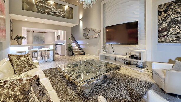A modern living room with a glass coffee table, a TV, and a staircase leading to an upper level. - Stunning Remodel 4 BR/3 BA Downtown ,Gaslamp, Petco, Convention Center (San Diego)