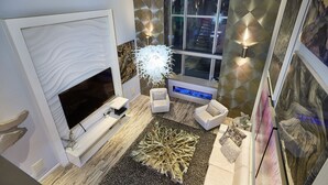 A modern living room with a fireplace, a large window, and a decorative rug. - Stunning Remodel 4 BR/3 BA Downtown ,Gaslamp, Petco, Convention Center (San Diego)