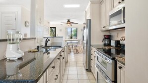 Una cocina moderna con encimeras de granito, electrodomésticos de acero inoxidable y una isla central.