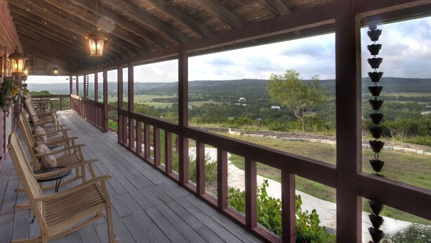 Un espace extérieur abrité, doté de bancs en bois et offrant une vue sur la campagne.