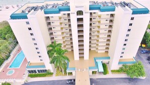Un hôtel à plusieurs étages doté d’une cour intérieure, de balcons et d’un espace piscine.