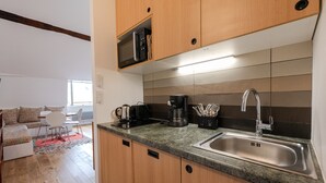 A modern kitchen with a built-in microwave, coffee maker, and stainless steel sink. - LATIN QUARTER, PARIS VIEW, 30–60 days ahead? Ask for a private offer. C5-VAs (Paris)