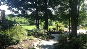 A stone pathway leading through a garden with a cross, surrounded by lush greenery and trees. - Chalet on 250 acres, Private, 1 Mi from Chautauqua Institution / Lake (Mayville)