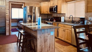 A modern kitchen with wooden cabinets, stainless steel appliances, and a granite countertop. - 12 miles to Yellowstone National Park, hot tub, fire pit, 3 bedrooms 3 bathrooms (Island Park)