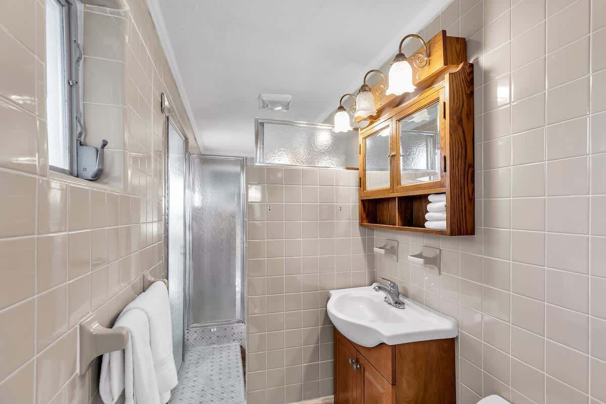 A modern bathroom with a shower, a sink, and a vanity with a mirror.
