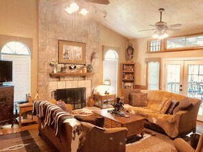 Cozy living area with a fireplace, sofa, chair, and TV.