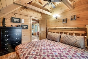 A wooden cabin bedroom with a bed, dresser, and ceiling fan. - Hidden Treasure in the heart of Pigeon Forge
50.00 off a night jan. and feb. (Pigeon Forge)