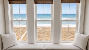 A window seat with a view of the beach and ocean.