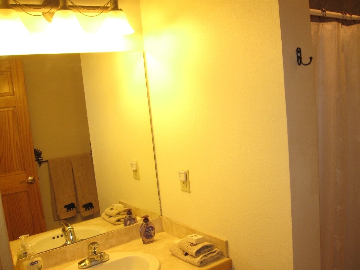 Une salle de bain équipée d’un lavabo, d’un miroir et d’un porte-serviettes.