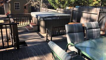 Relax on the deck with a hot tub and outdoor seating, surrounded by a patio area.