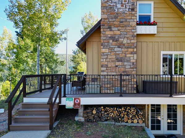 A two-story building with a stone facade, a wooden deck with a railing, and a sign prohibiting campfires.