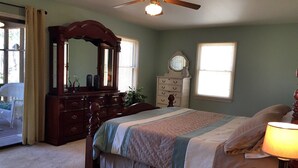 A bedroom with a bed, dresser, vanity, and a ceiling fan. - Amazing Waterfront Home in Private setting w/ fiber internet! (Bumpass)