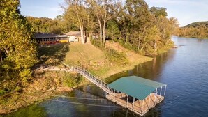 A riverside property with a wooden dock and a covered boat house. - Premier Riverfront Location ~ NEW BOATDOCK~ biking trails ~Bull Shoals Lake Fun (Lakeview)