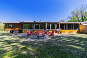 A house with a covered patio, a fire pit, and outdoor seating.