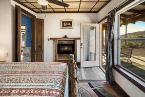 A bedroom with a bed, a fireplace, and a view of the outdoors. - Crystal Valley Cabin: Modern-Rustic Style&Comfort (Alpine)