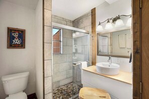 A bathroom with a glass shower enclosure, a white toilet, and a wooden vanity with a sink. - Crystal Valley Cabin: Modern-Rustic Style&Comfort (Alpine)