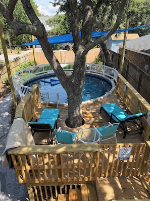 A backyard with a swimming pool, wooden deck, and outdoor furniture. - 5-bedroom vacation home, Last week of July promotion 30 % off Jul 26th - Aug 2nd (Folly Beach)