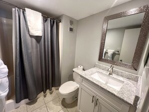 Kombination af bruser/badekar, hårtørrer, håndklæder