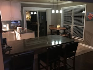 Enjoy casual dining in this kitchen with a central island, oven, and dining table near a window with a view.
