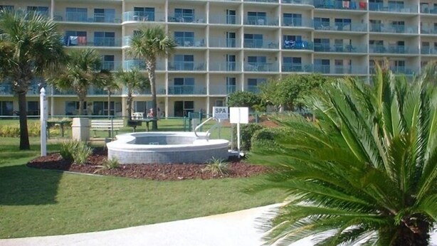 A multi-story hotel with balconies, a swimming pool, and palm trees. - Low Rates ! Gulf View; Palms, Grnd Flr; Weekly discounts (Gulf Shores)