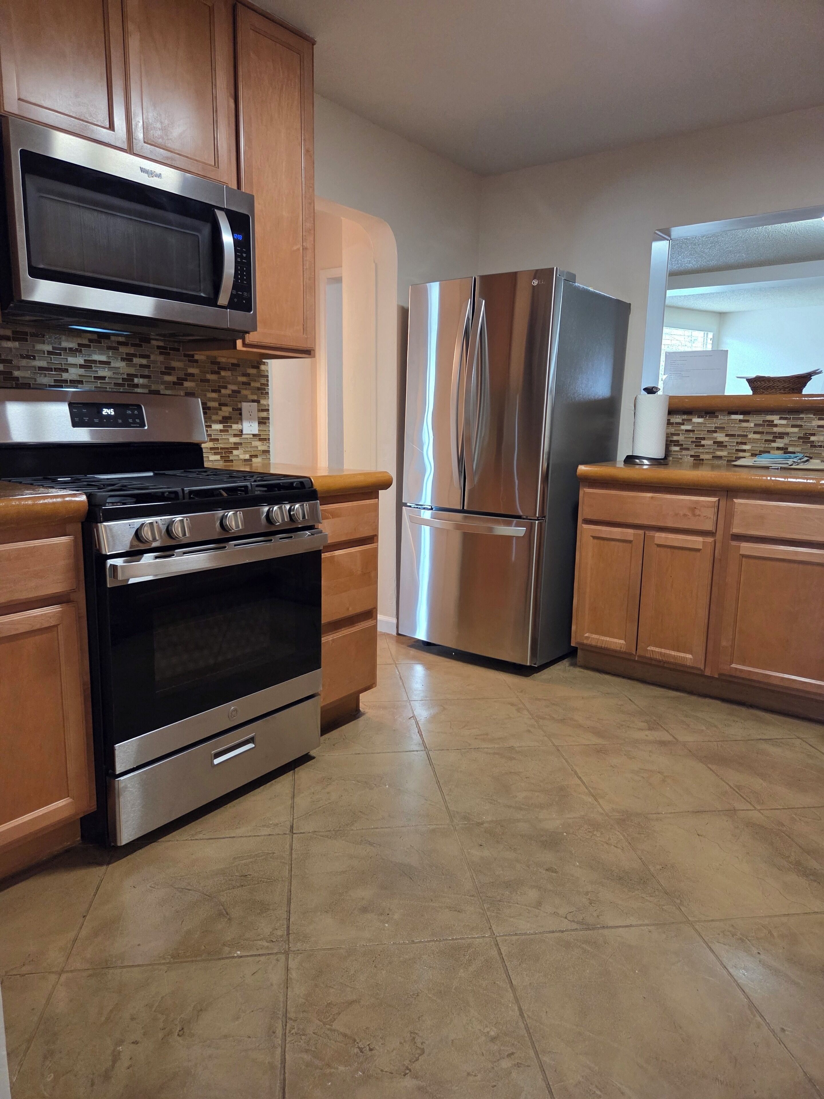 A kitchen with a stainless steel stove, oven, microwave, and refrigerator.