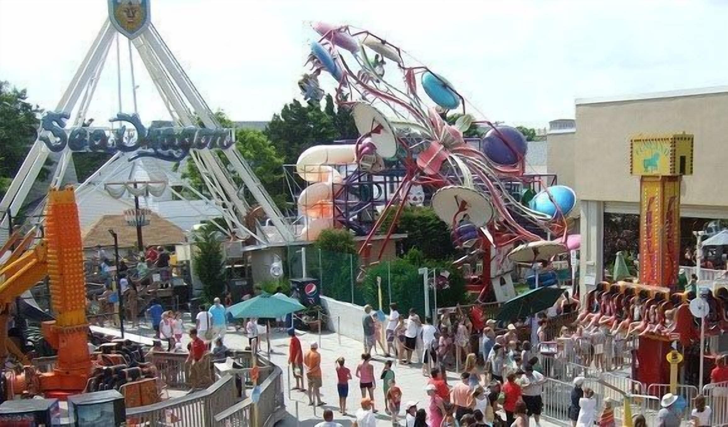 A crowded amusement park with various rides and attractions.