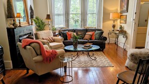 Un salon comprenant un canapé, des fauteuils, une table basse et une cheminée.