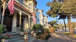 Un bâtiment historique doté d’une entrée imposante, de plusieurs drapeaux américains et d’un jardin bien entretenu.