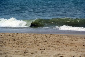 A beach with waves approaching the shore.