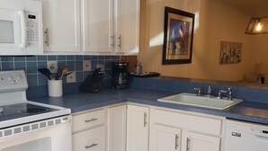 A kitchen with white cabinets, a microwave, a stove, a coffee maker, and a dishwasher. - Bethany Beach 3-BR Townhouse With Pool and Tennis - Walking Distance to Beach! (Bethany Beach)