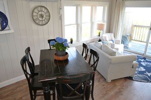 Un comedor con una mesa y sillas de madera, una planta en maceta y un reloj en la pared.