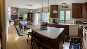 Una cocina con armarios de madera, una isla grande y una zona de comedor con mesa y sillas.