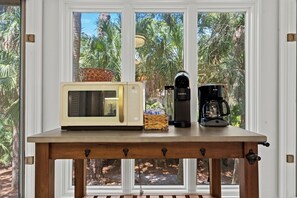 A kitchen counter with a microwave, coffee maker, and basket. - Beachwalk Cottage – Steps to Beach, Free Seasonal Pool Heat, Sleeps 10, 4 King Suites (Hilton Head Island)